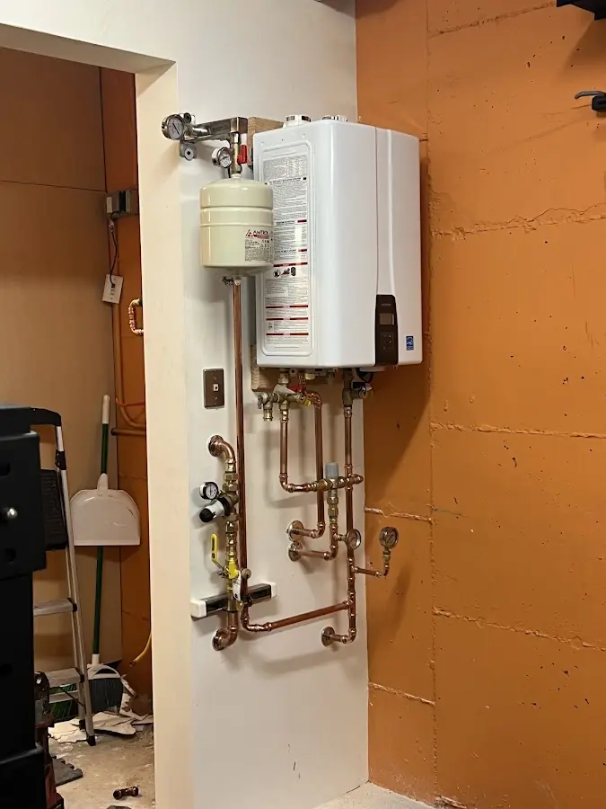 Plumbing technician inspecting water heater connections in Point Pleasant